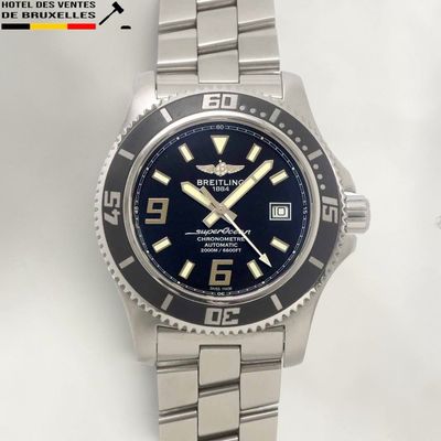 the watch is on a silver bracelet with a blue dial
