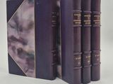 trois livres sont alignés sur une surface blanche
