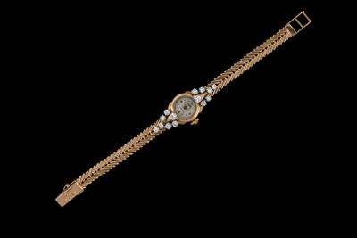 une montre-bracelet en or sertie de diamants sur fond noir