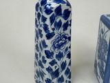 two blue and white vases sitting next to each other