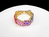 yellow gold plated ring with multi colored stones on a white surface