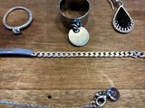 de nombreux bijoux en argent posés sur une table en bois