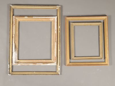 deux cadres dorés accrochés au mur à côté d'un miroir