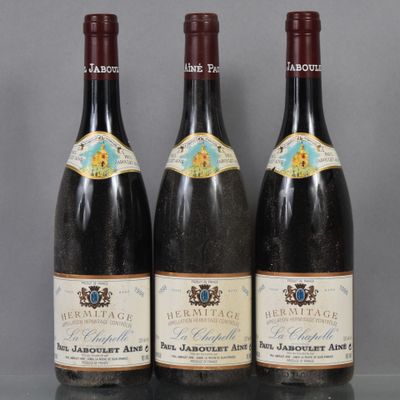 trois bouteilles de vin sont alignées sur une table