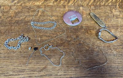 a wooden table with a pair of scissors and a necklace on it