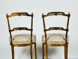 pair of antique chairs with upholstered seats on a parquet floor
