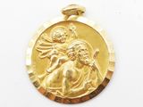 un gros plan sur une médaille d'or représentant Jésus et un enfant