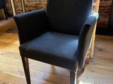 a black chair sitting in a room with a brick wall