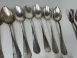a lot of spoons and forks lined up on a table