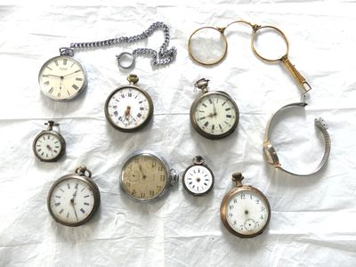 de nombreux modèles différents de montres de poche posés sur un drap blanc