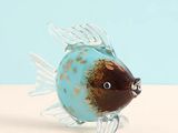 a glass fish figurine sitting on top of a table