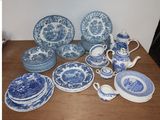 many blue and white plates and cups on the table