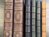 cinq vieux livres sont alignés sur une table