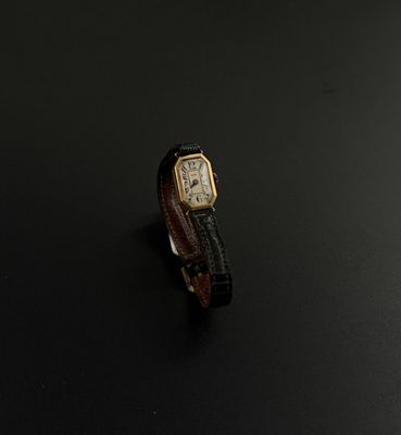 une image représentant une montre-bracelet posée sur une surface noire