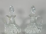 two clear glass vases sitting next to each other on a white surface