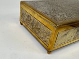 a gold box that is sitting on a white surface
