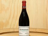 a bottle of wine sitting on top of a barrel