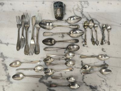 de nombreuses cuillères et fourchettes disposées sur une table en marbre