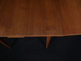 a close up of a wooden table with two leaves on it