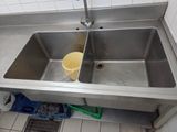 two sinks in the kitchen with a yellow bucket in the sink