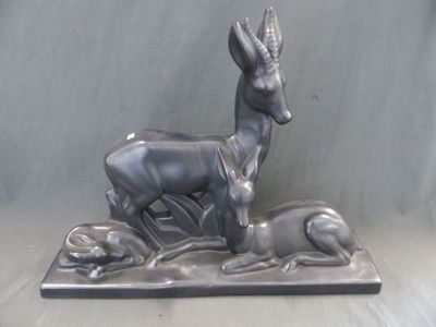 statue représentant un cerf et un chien posés sur un socle, sur fond gris