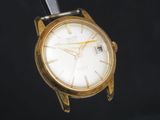 une montre-bracelet en or avec un cadran blanc sur fond noir