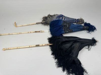 deux parapluies ornés de plumes, posés sur une table