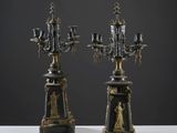 une paire de chandeliers noirs et dorés ornés de figures