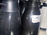 three black vases sitting on a counter in a kitchen