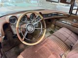 dashboard of an old car with a wooden steering wheel and a leather seat