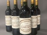 six bouteilles de vin sont alignées sur une table