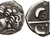 a close up of a coin with a face on it