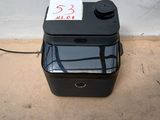 une boîte noire sur laquelle est collé un autocollant, posée par terre