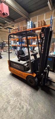 a fork lift truck in a warehouse with pallets on the floor