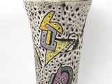 un vase avec un motif sur une surface blanche