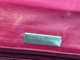 the handle of a pink purse with a name plate on it