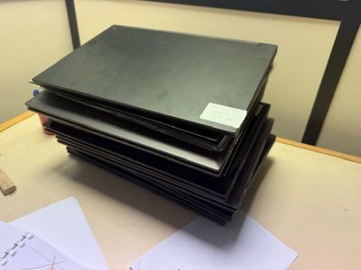 une pile de papiers posée sur un bureau, à côté d'un ordinateur portable