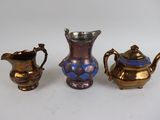 three pieces of silver and blue glass on a white surface