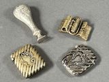 trois bijoux en argent et en or posés sur une surface grise
