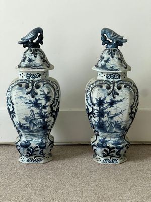 une paire de vases bleus et blancs surmontés d'oiseaux