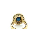 an image of a gold ring with a blue stone surrounded by diamonds