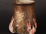 a brown vase with two hands sticking out of it