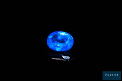a close up of a blue crystal on a black surface