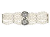 un gros plan sur un bracelet blanc orné de perles et de diamants
