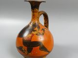 a vase with a bird on it on a white surface