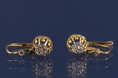 deux paires de boucles d'oreilles en or et diamants sur un fond bleu