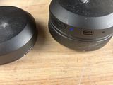 the black headphones are sitting on the wooden table next to each other
