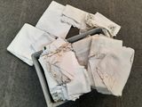 a box full of folded white cloths on the floor