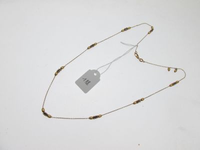 gros plan d'un collier sur une surface blanche avec une étiquette de prix