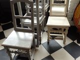 plusieurs chaises et une table dans une pièce au sol à carreaux noirs et blancs